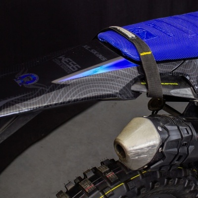 Parte traseira de mota off-road com selim azul e escape metálico