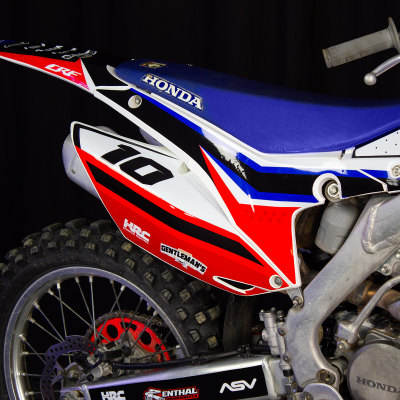 Motocross Honda azul, vermelha e branca com número 10 na lateral