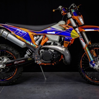 Motocross KTM laranja e azul com número 19 e autocolantes PIRELLI, MOTOREX, RENTHAL e BREMBO