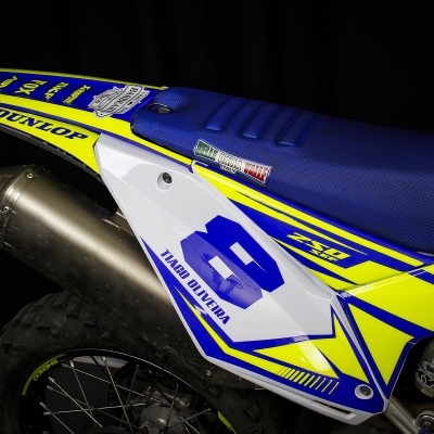 Parte traseira de mota com banco azul e carenagem branca, amarela e azul