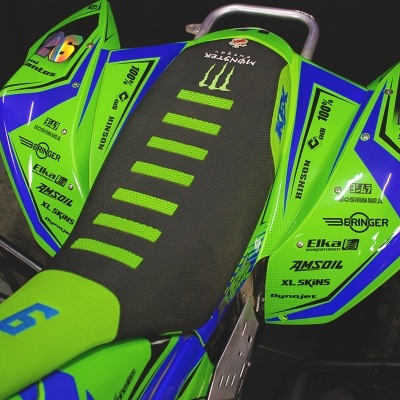 Assento de mota de corrida verde e azul com números e logotipos visíveis