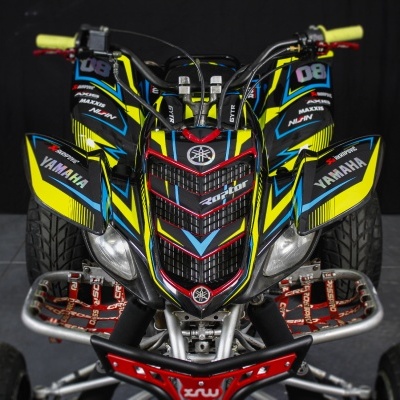 Quadriciclo preto com detalhes em amarelo, azul e vermelho e texto YAMAHA
