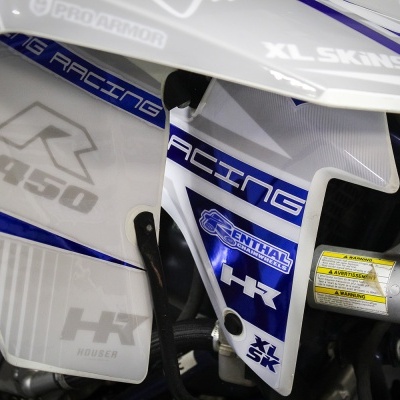 Carenagens laterais de mota de motocross branca e azul com textos e etiquetas