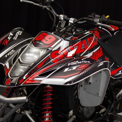 Quadro todo-o-terreno preto, vermelho e branco com texto Suzuki e número 69