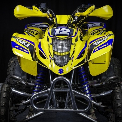 Quadriciclo amarelo Suzuki com números 12 e detalhes azuis