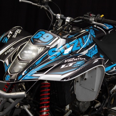 Quad azul e preto Suzuki com número 69 e suspensão vermelha