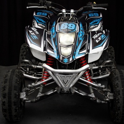 Quadriciclo preto, azul e branco com número 69 na frente