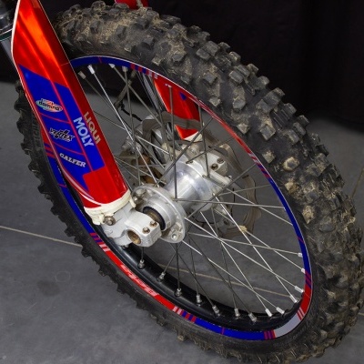 Roda dianteira de bicicleta de montanha com pneu de cravos e aro colorido