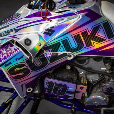 Parte lateral de moto Suzuki com pintura holográfica e texto