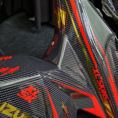 Peças de moto em fibra de carbono com detalhes coloridos e textos SUZUKI e XL-SKINS