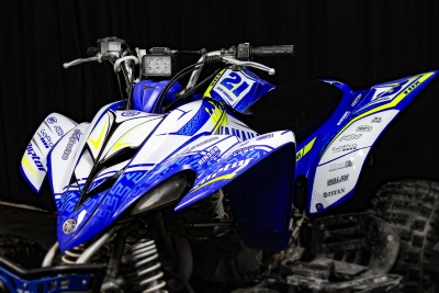 Veículo todo-o-terreno azul e branco com número 21 e autocolantes nas laterais