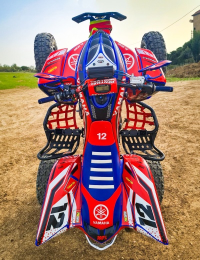 Quad YAMAHA vermelho, azul e branco com número 12 em terra batida