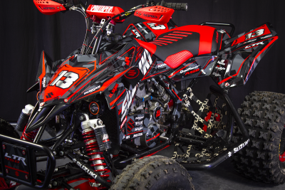 Quadriciclo Suzuki LTR 450 preto, vermelho e cinzento com o número 13, suspensão vermelha e pneus com rasto grosso