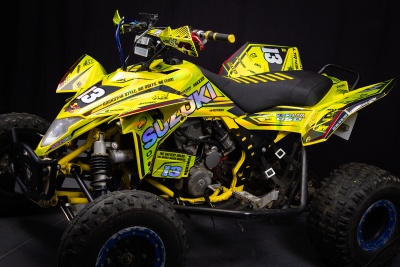 Quadriciclo Suzuki amarelo com número 13 em fundo preto