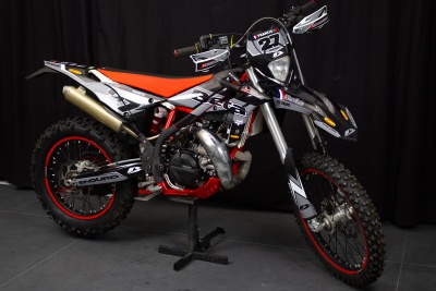 Motocross preta, branca e vermelha com pneus de terra e detalhes vermelhos.