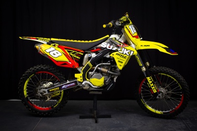 Motocross Suzuki amarela com número 18 e pneus Maxxis