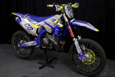 Mota de motocross azul, branca, amarela e preta com números 08 e marca Sherco