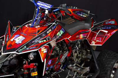 Quadro todo-o-terreno Suzuki vermelho, preto e branco com cadeado, número 14 e gráficos distintos