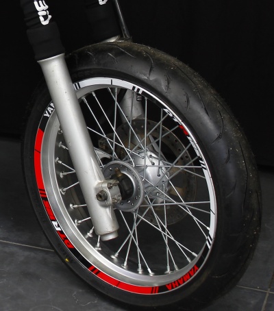 Roda dianteira de mota Yamaha com textos vermelhos e brancos no aro
