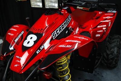 Veículo todo-o-terreno vermelho com autocolantes e número 8