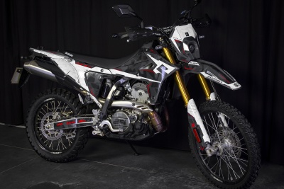 Motocross Suzuki DR-Z branco, cinzento e preto com detalhes em vermelho e dourado sobre fundo preto