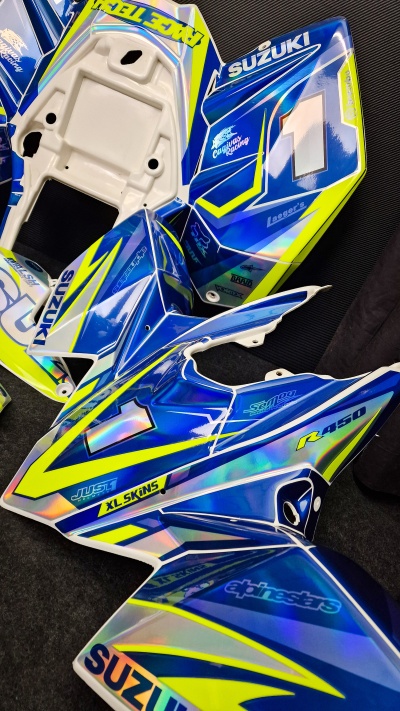 Peças de carenagem para mota Suzuki em plástico azul, amarelo e branco com texto impresso