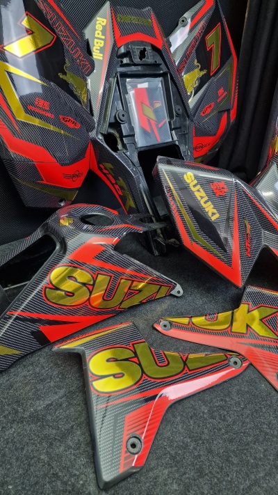 Carenagens para mota em padrão fibra de carbono com textos Suzuki, Red Bull e número 7.