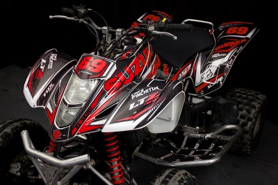 Quadriciclo Suzuki preto, vermelho e branco com número 69 e design gráfico