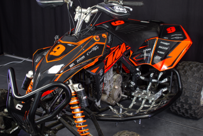 Quad de corrida preto e laranja com número 9 e logos de marcas
