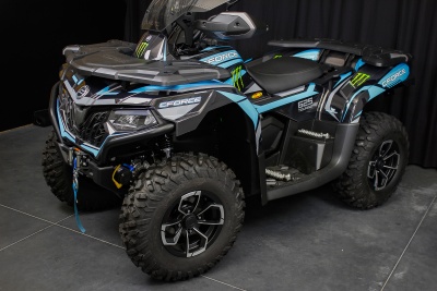 Veículo todo-o-terreno ATV CFORCE 850 preto, azul e verde, com pneus largos e faróis dianteiros.