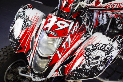 Quadriciclo desportivo vermelho, branco e preto com desenhos de caveira e texto LTZ 400