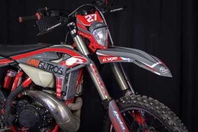 Motocross vermelha e cinzenta com número 27 e patrocínios