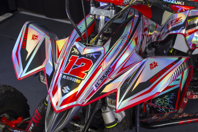 Triciclo Suzuki vermelho, preto e prateado com o número 12 e textos XL-SKINS e SUZUKI XL SK