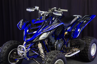 Quad Yamaha azul e preto com texto RACETECH e pneus de borracha em estúdio escuro