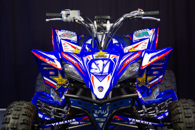 Quad Yamaha azul com autocolantes coloridos e pneus todo-terreno