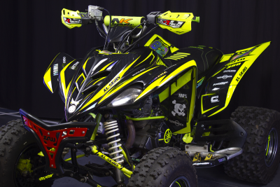 Quad Yamaha Raptor 350 amarelo fluorescente e preto com pneus todo-o-terreno e suspensão visível