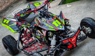 Quadriciclo preto, verde e vermelho com número 11 e design esportivo