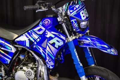 Motocross Yamaha azul metalizado com padrões geométricos e números 88 no para-brisas
