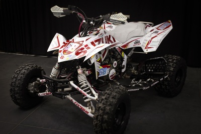 Quadriciclo branco e preto com autocolantes vermelhas e assento cinzento