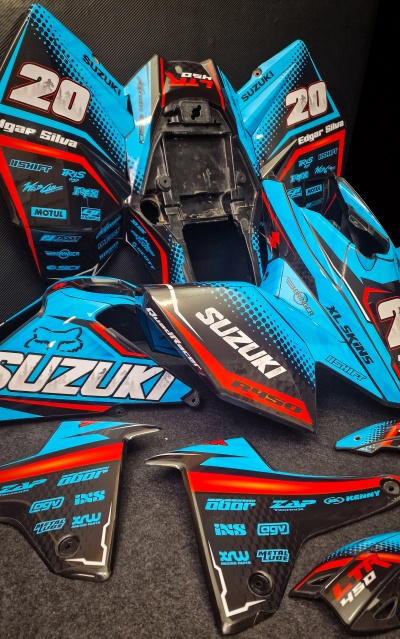 Conjunto de peças de carenagem Suzuki azul, preto, vermelho e branco com vários logótipos e textos visíveis