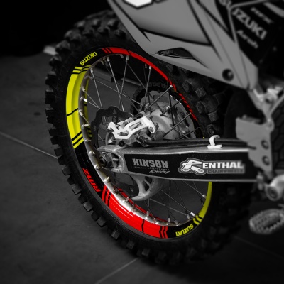Roda traseira de mota de motocross com aro colorido e marcas Suzuki, Hinson, Renthal