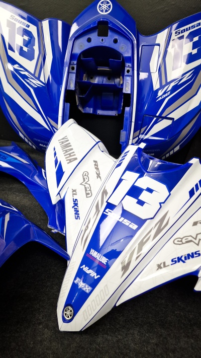 Carenagens azuis e brancas para moto Yamaha com números 13 e várias marcas