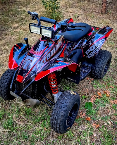 Quadriciclo Polaris Scrambler 4x4 preto e vermelho com luzes frontais e pneus grossos