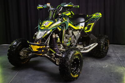 Quad Suzuki LTZ verde, amarelo e preto com número 5 em fundo cinzento e preto