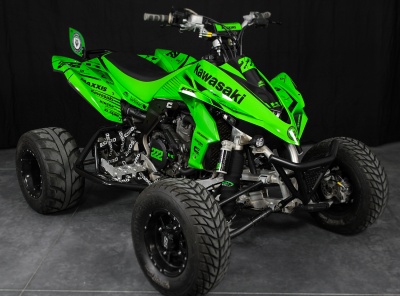Quad Kawasaki verde e preto com números 222 e vários autocolantes em fundo escuro