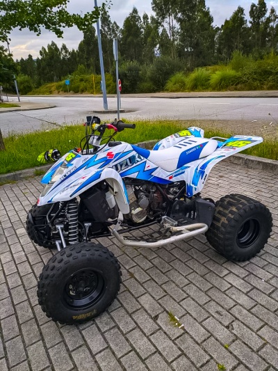 Quad Suzuki azul e branco com pneus largos e detalhes amarelos