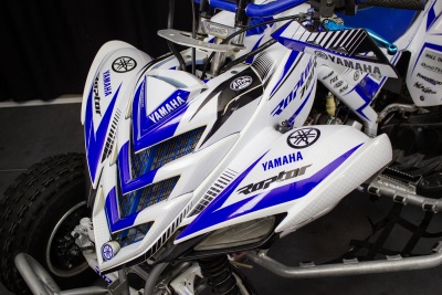 Veículo de três rodas branco e azul com logotipos YAMAHA e detalhes gráficos