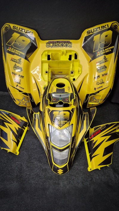 Peças amarelas da carenagem de motocicleta Suzuki com número 19 e logótipos