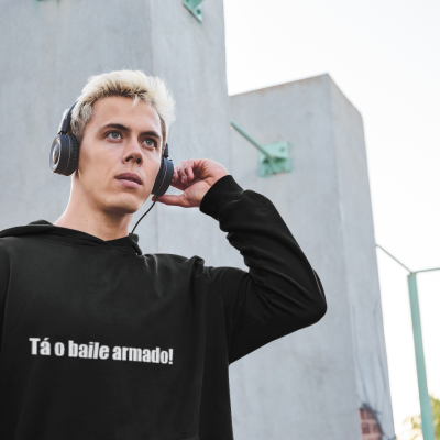 Homem com auriculares e camisola preta com texto Tá o baile armado!