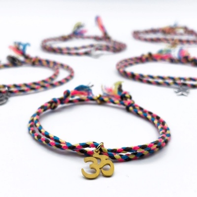 Pulseira colorida trançada com pendente metálico dourado